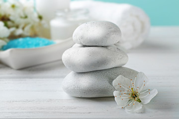 Fototapeta na wymiar Spa stones with flower on white wooden table