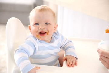 Fototapeta premium Little baby feeding with a spoon