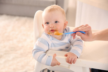 Little baby feeding with a spoon