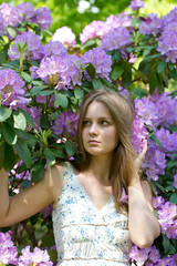 beautiful young woman and blooming rhododendron