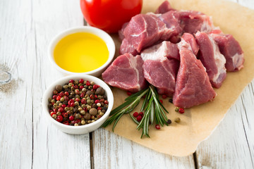 raw pork neck meat cut in pieces on wooden table