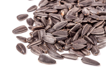 unpeeled sunflower seeds on a white background