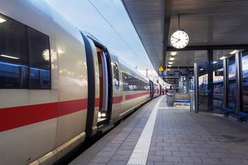 High speed passenger train on railroad platform. Railway station in Nuremberg, Germany.