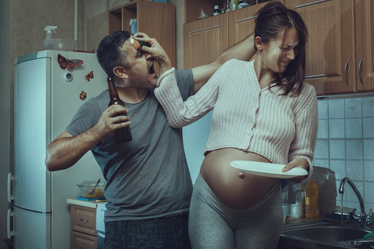 Husband and wife fighting in the kitchen.