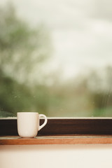 White single tea or coffee mug on window
