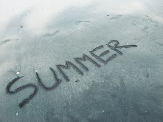 Word summer written in sand on beach