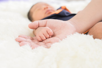 Hand the sleeping baby in the hand of mother close-up (Soft focu