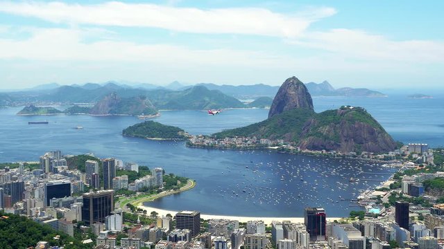 Airplane flying in front of Sugar Loaf Mountain before landing at Santos Dumont airport in Rio de Janeiro, Brazil.