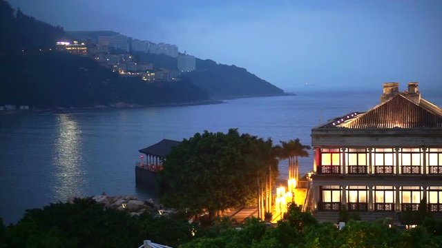 Stanley Beach harbour, Hong Kong: April 2016 - Lighted Murray House and plaza view to the ocean in evening  