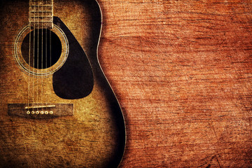 Naklejka premium Guitar on wooden background vintage