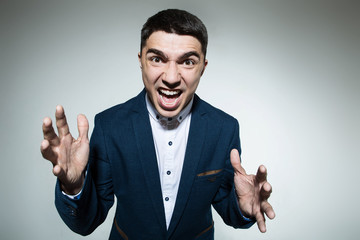 Portrait of screaming angry young man on a light background