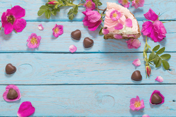 pink rose and cake on wooden background