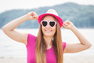 Happy girl tourist in straw hat and sunglasses on beach, free time on seaside