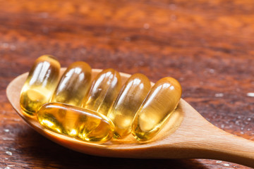Fish oil capsule in the spoon is nutrition food for healthy. (selected focus)