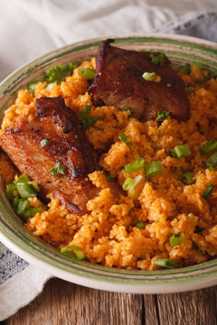 Asian bulgur pilaf with meat close up on a plate. vertical
