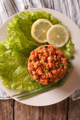 Turkish appetizer spicy kısır of bulgur with herbs on the table. Vertical top view
