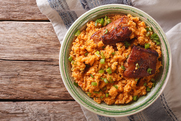 spicy bulgur with beef close-up on a plate on the table. Horizontal top view
