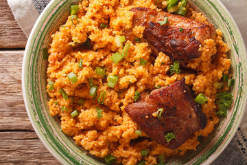 Pilaf bulgur and beef close-up on a plate on the table. horizontal top view 
