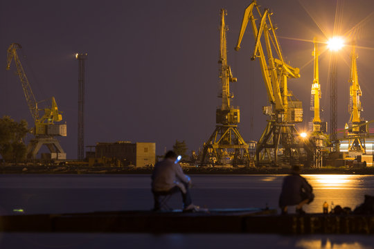 Sea of Azov. Mariupol sea trading port. Fishermen on the breakwa
