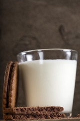 Bitten biscuit and one glass of milk