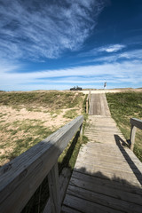 Fototapeta na wymiar Wooden walkway across the beach on the Uruguayan eco-lake Garzon