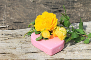 Soap and rose on wooden background