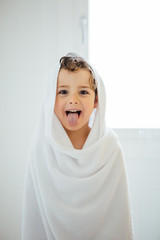 Lovely kid in towel sticking out tongue