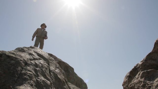 Man jumping over rocks against the sky