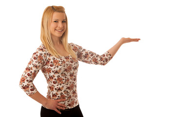 Cute blond woman pointing into copy space as she is showing a pr