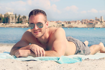 Handsome male lying on the sand