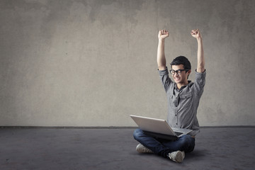 Jubilant young student with laptop