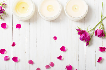 roses with candles on a wooden background