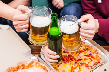 Close up of home fans eating: pizza and beer