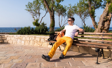 guy sitting on a bench near the sea