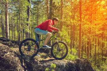 Fototapeta na wymiar Man with the bike riding on a rock