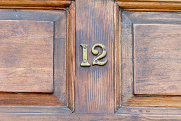 House Number 12 sign on wooden door