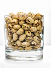 Recipiente con pistachos aislados en fondo blanco