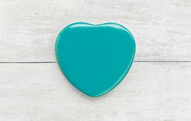 Green heart shape on white wood background