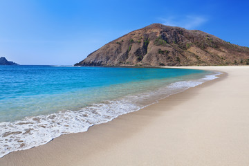 Beautiful scene on best desert beach with white sand, clear water on ocean bay Mawun in tropical island Lombok. Boundless tropic beach with no people in lost paradise. Travel and vacation in Indonesia