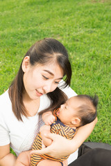 asian 2 months baby feeling happy and smiles with her mother in