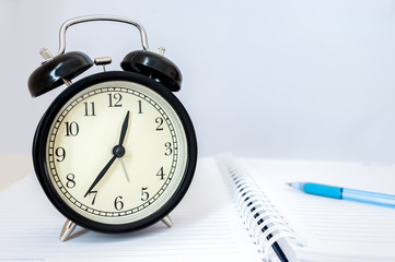 Retro alarm clock with retro colored in white background, white background with retro alarm clock on table, Big old vintage alarm clock with bells, painted white wooden background