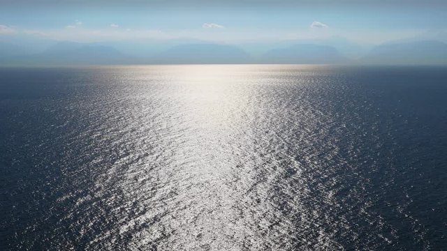 Seascape rippled water surface reflection sea sky mountains in the background