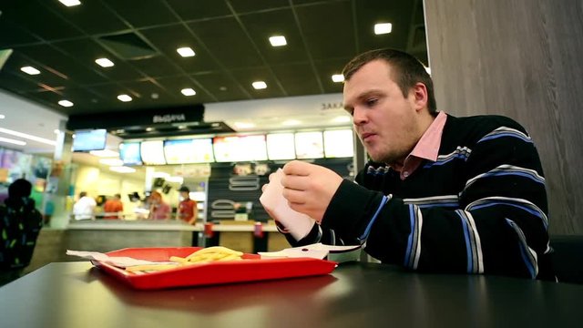 Man In Fastfood Eating French Fries
