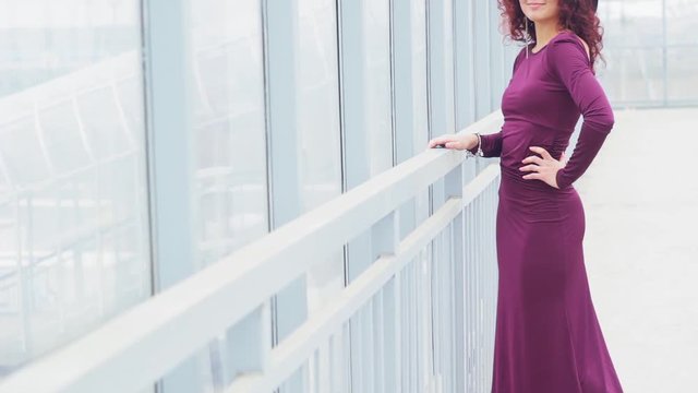 Beautiful curly-haired woman in a long dres