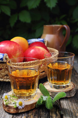 Apple juice in two glass on old wooden table