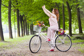 Naklejka premium Beautiful girl on bike taking a selfie