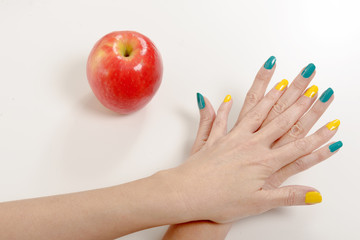 woman hands and a red and yellow apple