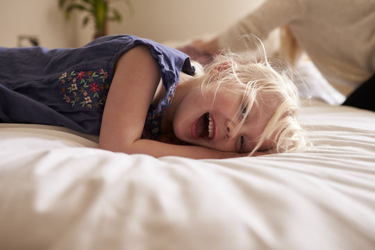 Portrait Of Young Girl Lying On Parent's Bed