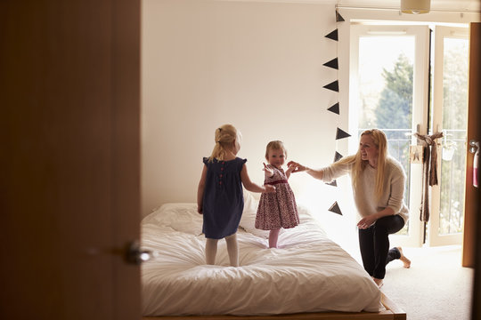 Mother Playing Game With Daughters In Bedroom