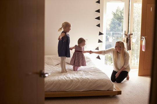 Mother Playing Game With Daughters In Bedroom